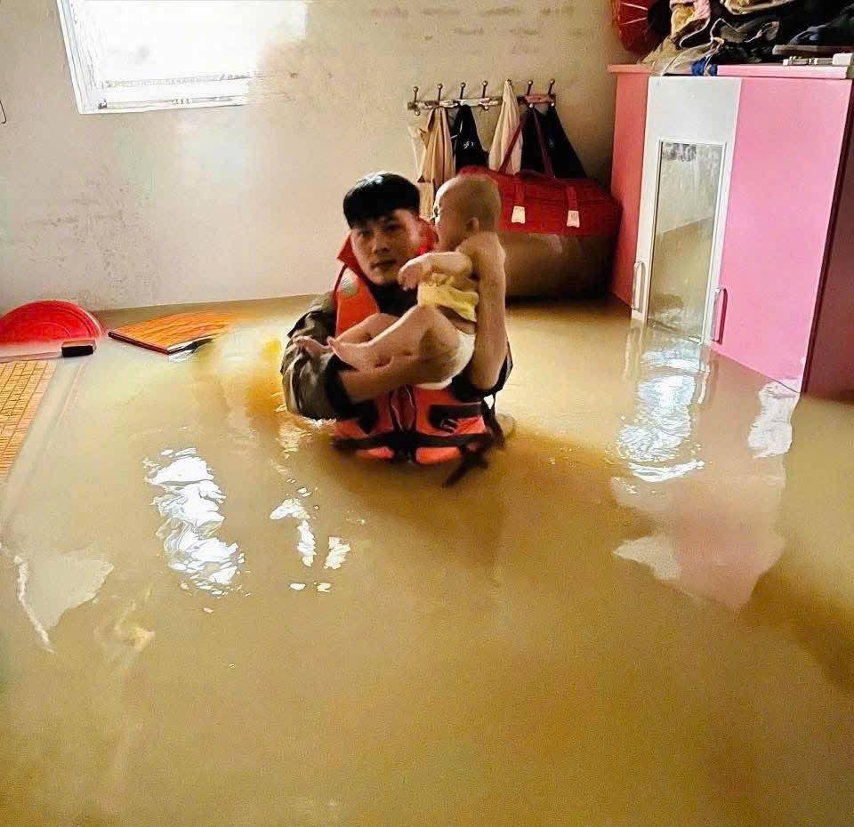 Cán bộ Công an tỉnh Nghệ An dầm mình trong nước sâu cứu người. Ảnh: Ngọc Anh