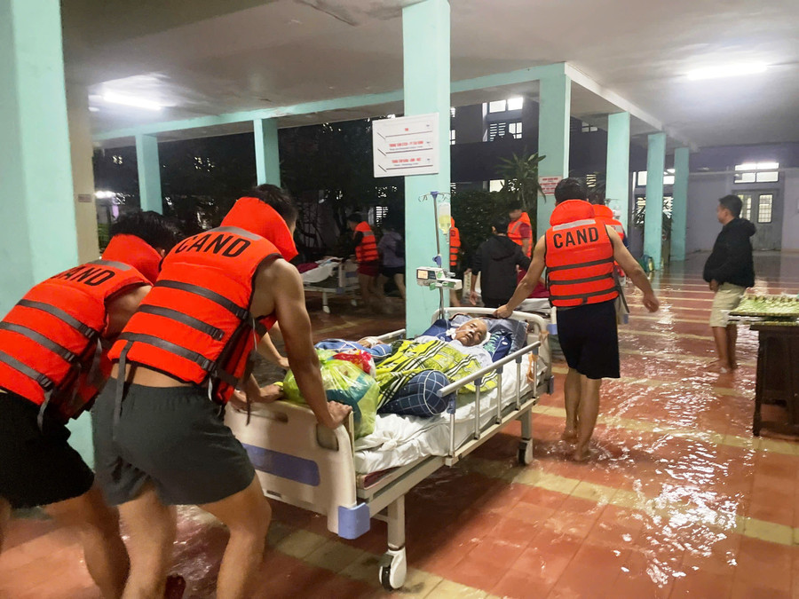 Các chiến sĩ công an xuyên đêm giúp vận chuyển bệnh nhân lên cao tại bệnh viện bị ngập lũ.