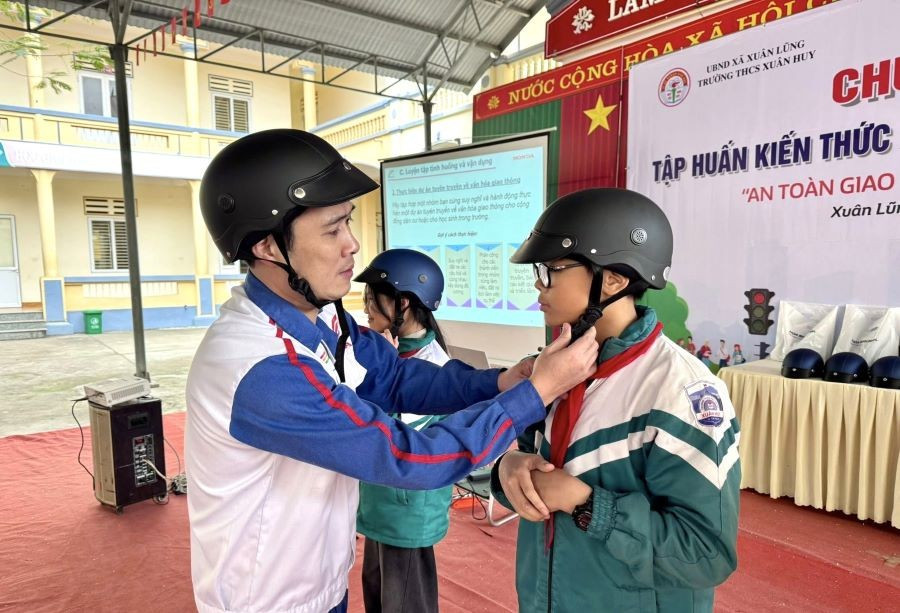 Học sinh trường THCS Xuân Huy được hướng dẫn cách đội mũ bảo hiểm đúng quy cách. xuan-huy-3.jpg
