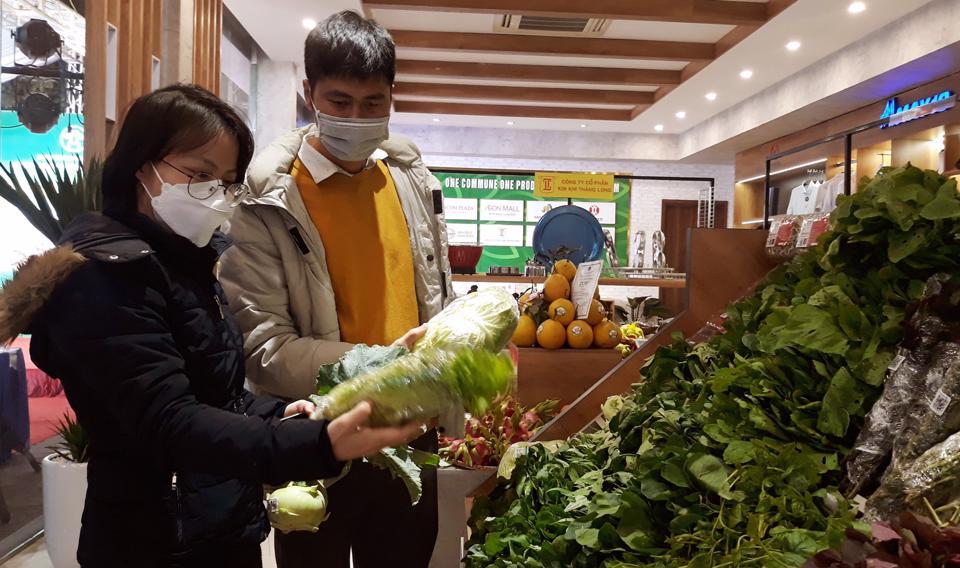 Người tiêu dùng mua sản phẩm tại cửa hàng bán và giới thiệu sản phẩm OCOP ở quận Long Biên