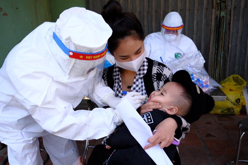 Xét nghiệm Covid-19 cho trẻ em tại thôn Liễu Trì, xã Mê Linh, huyện Mê Linh. Ảnh: Công Hùng