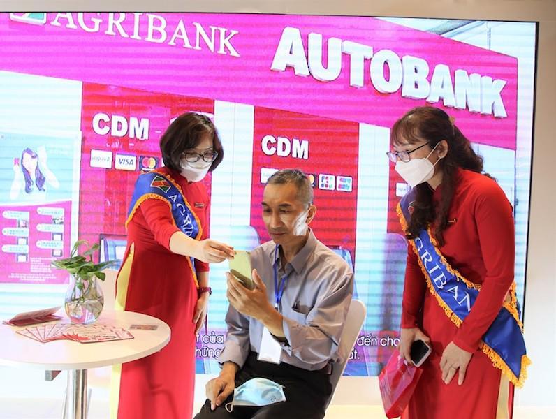 Nhân viên Agribank giới thiệu với đại biểu và khách tham quan trải nghiệm các dịch vụ ngân hàng số của Agribank