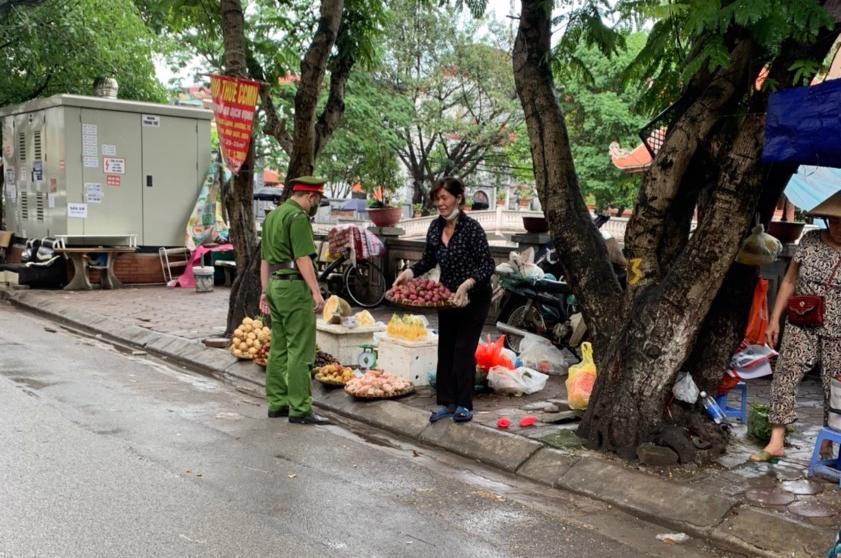 Lực lượng chức năng kiểm tra xử lý trường hợp lấn chiếm vỉa hè làm nơi kinh doanh sai quy định trên phố Dịch Vọng.