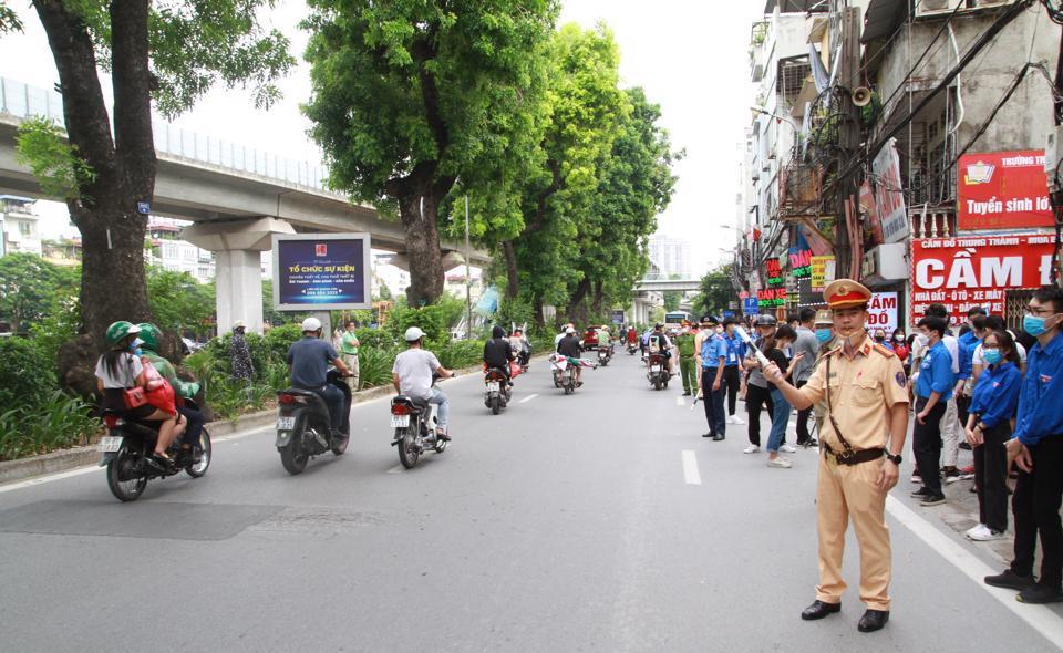 Cùng với cảnh sát giao thông, lực lượng thanh niên tình nguyện cũng nhiệt tình hỗ trợ công tác phân làn giao thông tại kỳ thi tốt nghiệp THPT 2022. Ảnh: Văn Trọng