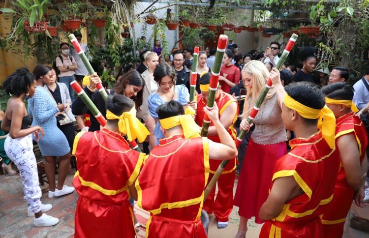 Các thí sinh trải nghiệm giã bánh giầy cùng các nghệ nhân.