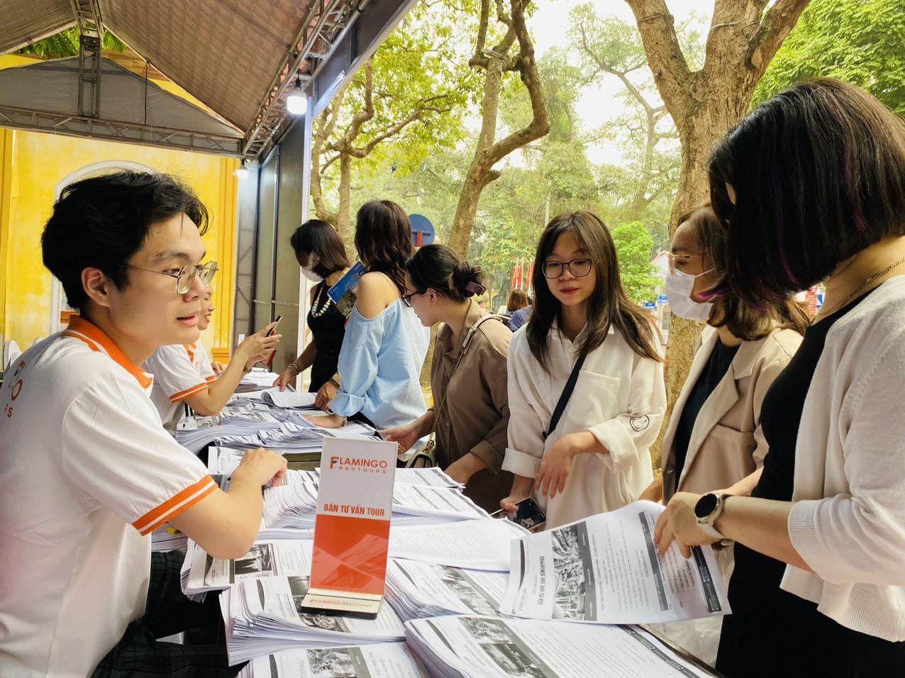 Khách tham quan Lễ hội Du lịch Hà Nội 2023 tham khảo các sản phẩm tour du lịch dịp 30.4 và hè năm nay. Ảnh: Bích Huệ