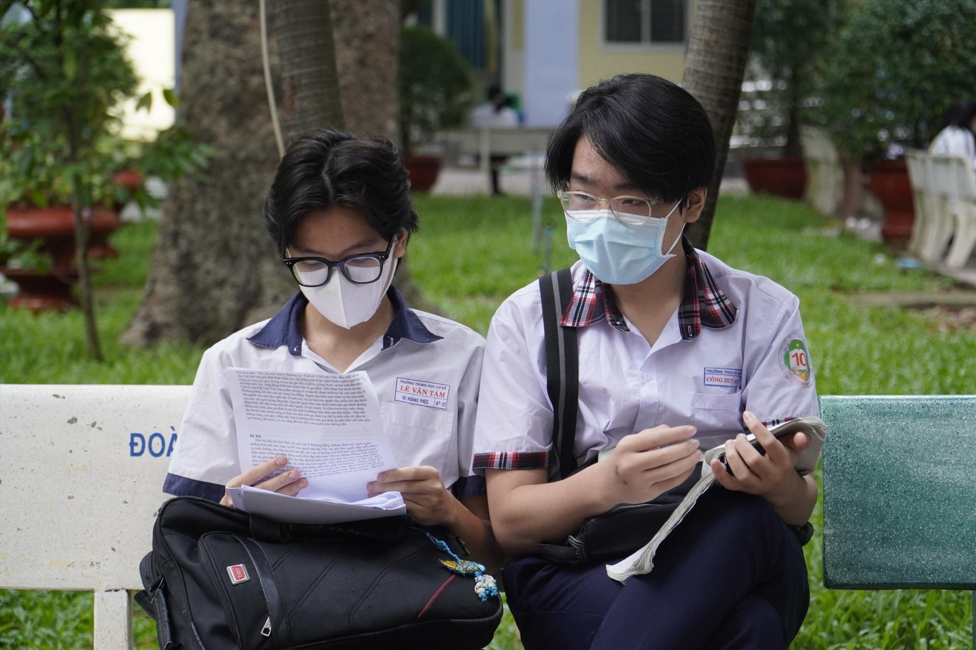 Hoàng Phúc (bìa trái) đang tranh thủ thời gian trước khi vào phòng thi ôn lại kiến thức. Ảnh: Ngọc Lê