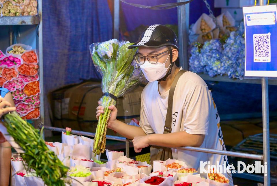 Nhiều chàng trai tranh thủ đến chợ hoa đêm để mua những bông hoa dành tặng cho người thân và bạn bè nhân ngày Phụ nữ Việt Nam 20/10.