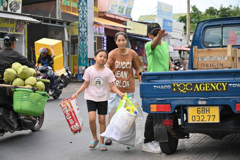 Người dân mang rác thải nhựa đổi lấy quà. (Ảnh Tiểu Sanh)