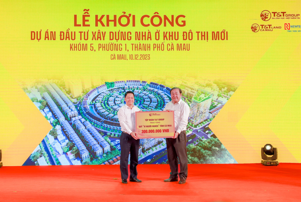  Thành viên HĐQT, Phó Tổng Giám đốc T&T Group Nguyễn Ngọc Nghị (bên trái) trao biển ủng hộ Quỹ Vì người nghèo tỉnh Cà Mau 300 triệu đồng cho Chủ tịch Uỷ ban MTTQ Việt Nam tỉnh Cà Mau Trần Văn Hiện (bên phải).