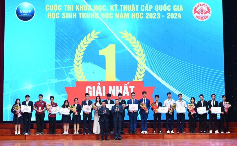 Thứ trưởng Bộ GD&ĐT Phạm Ngọc Thưởng trao giải Nhất và tặng hoa cho các dự án. Ông Nguyễn Đức Nguyên - Phó Trưởng ban Thanh niên trường học Trung ương Đoàn trao huy hiệu tuổi trẻ sáng tạo. Ảnh Đăng Chung.