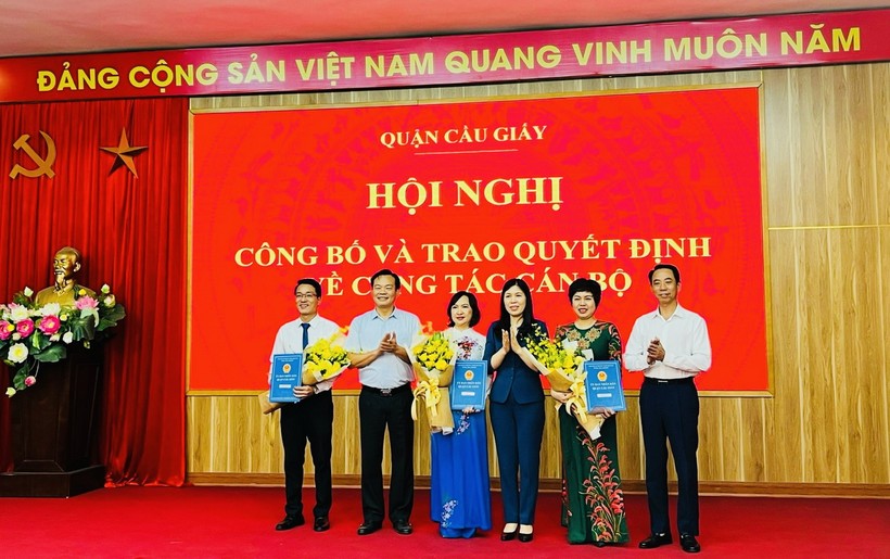 Các ông/bà: Trần Thị Phương Hoa - Thành uỷ viên, Bí thư quận uỷ quận Cầu Giấy, Nguyễn Văn Chiến - Phó Bí thư thường trực, Chủ tịch Hội đồng nhân dân quận, Bùi Tuấn Anh - Phó Bí thư quận uỷ, Chủ tịch uỷ ban nhân dân quận chúc mừng và trao quyết cho Ban giám hiệu Trường Tiểu học Nguyễn Viết Xuân.