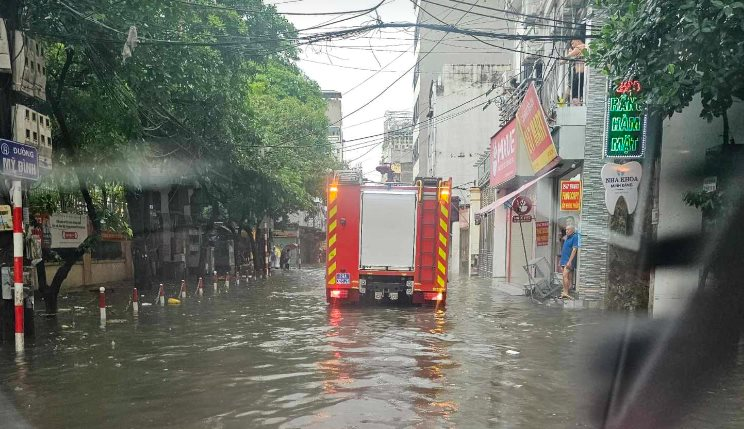 Xe cứu hoả qua đoạn đường mưa ngập vào hiện trường.