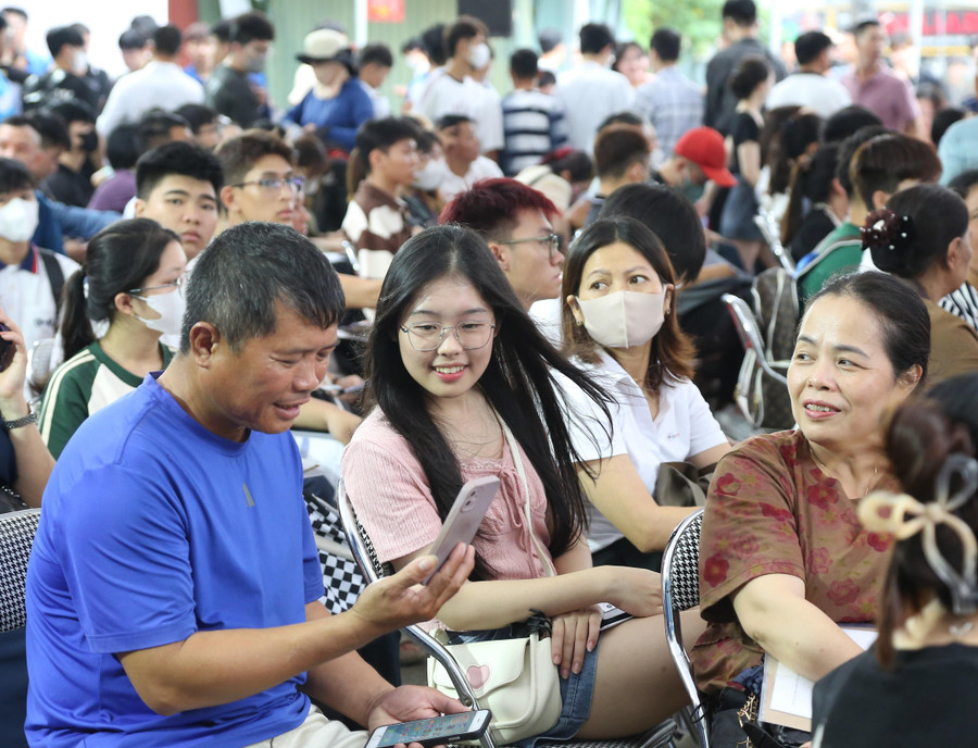 Phụ huynh, tân sinh viên chia sẻ niềm vui với gia đình trong ngày nhập học.