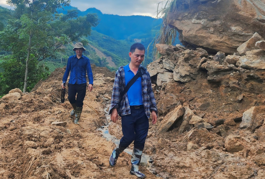 Anh Lê Trung Kiên (đi sau) cùng ê kíp của Đài Phát thanh -Truyền hình Lào Cai di chuyển đến Làng Nủ sau thảm họa để tác nghiệp.