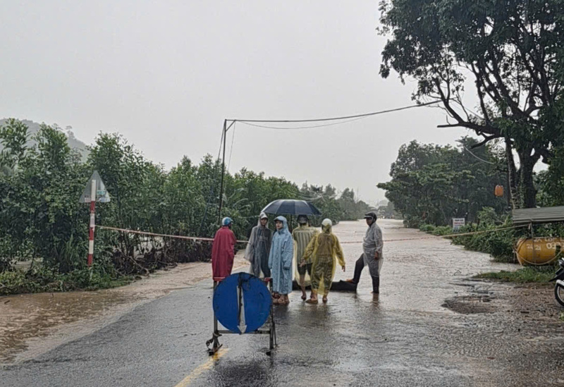 Quốc lộ 29 bị ngập, lực lượng chức năng giăng dây ngăn phương tiện đi lại. Ảnh: Phạm Lâm