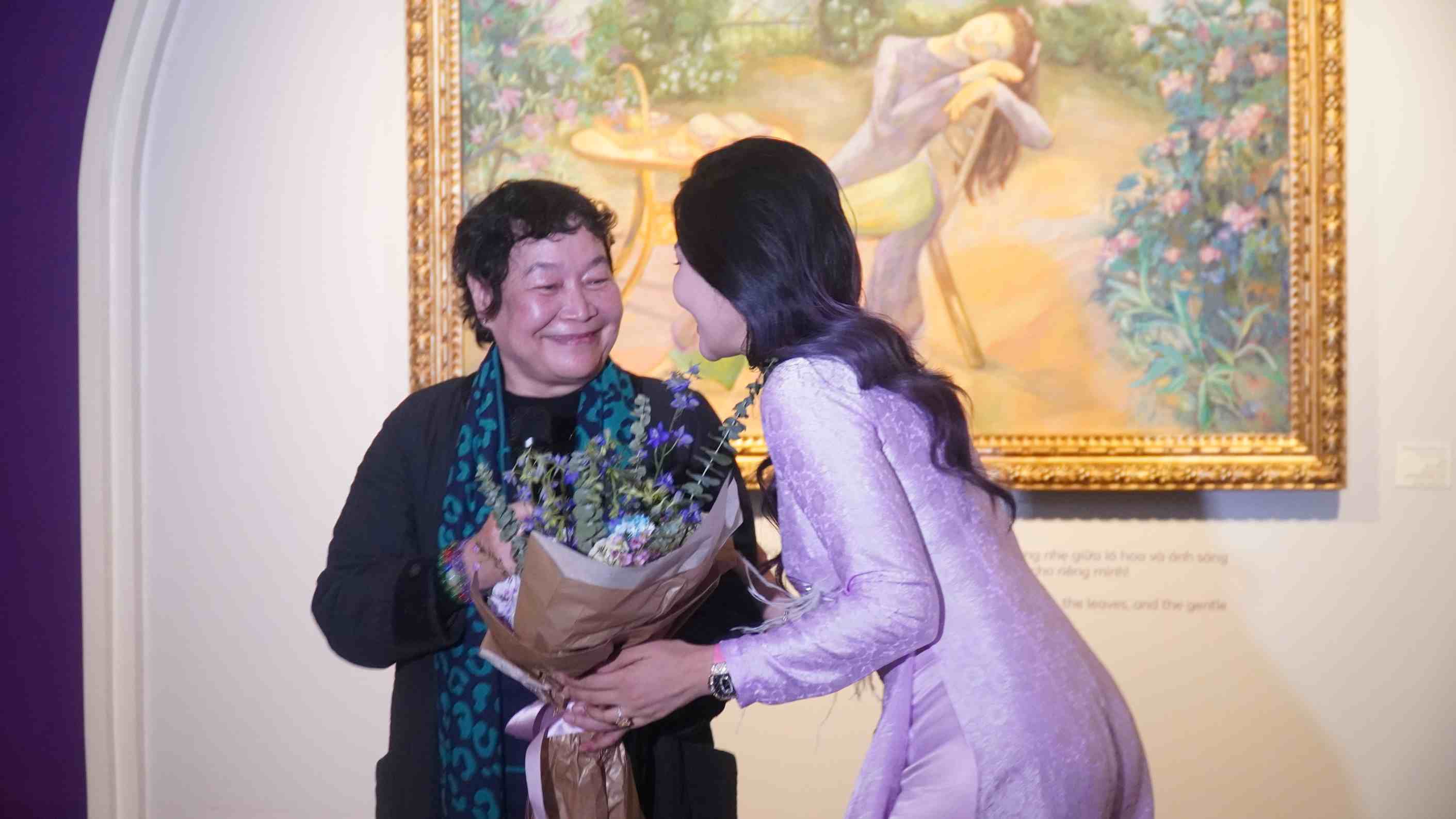 Bà Mai Thị Ngọc Oanh nhận hoa từ nữ họa sĩ Lê Trang sau khi phát biểu. Ảnh: Minh Vũ.