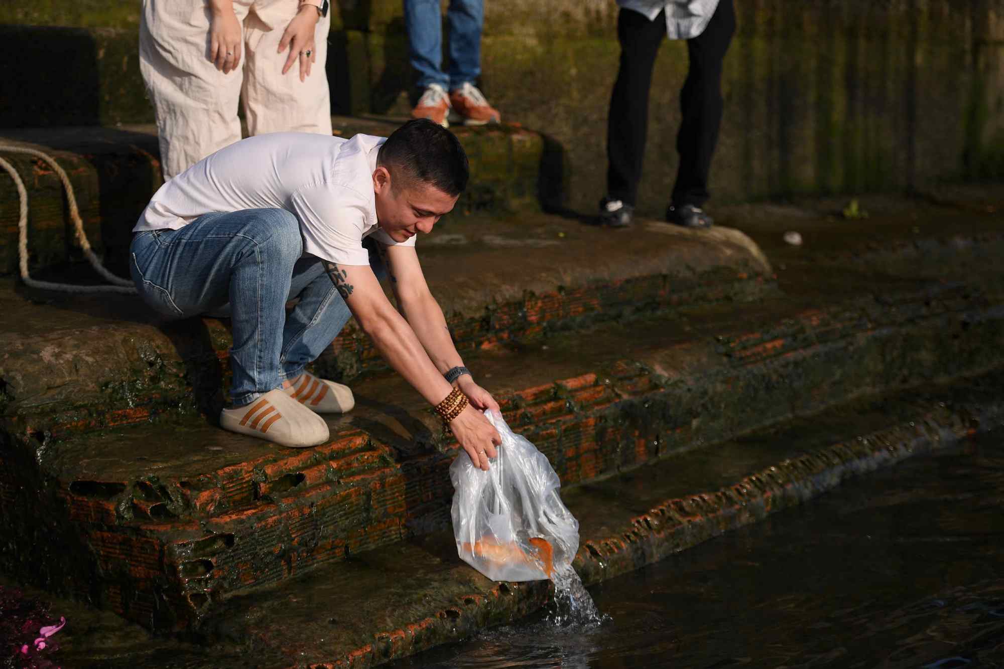 Người dân thành tâm thả cá chép theo phong tục truyền thống dịp 23 tháng Chạp.