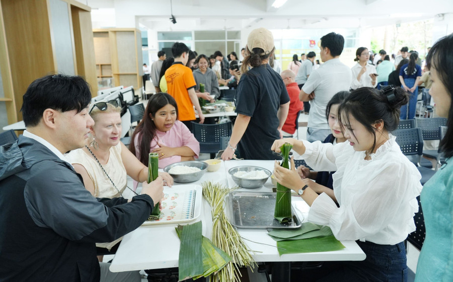 Sinh viên quốc tế Trường Đại học Sư phạm - Đại học Đà Nẵng trải nghiệm gói bánh chưng, bánh tét. Ảnh: NTCC
