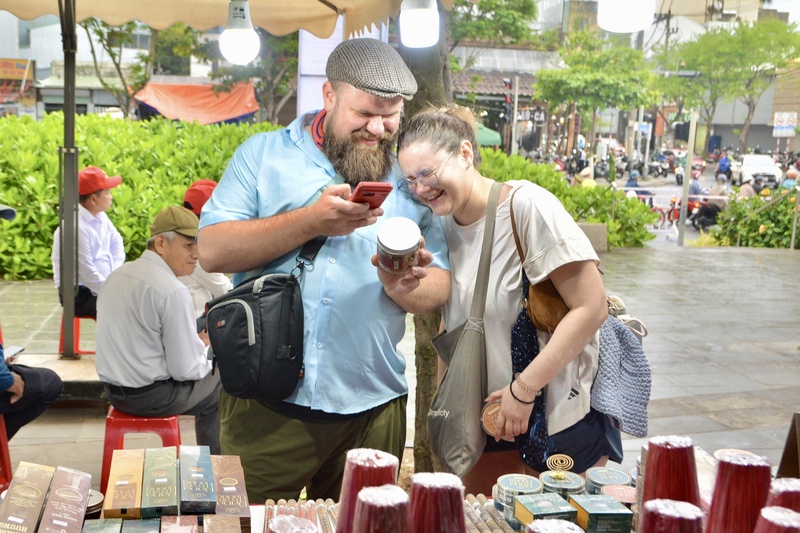 Du khách quốc tế tham quan, mua sắm tại gian hàng trưng bày sản phẩm OCOP, đặc sản vùng biển và ẩm thực địa phương. Ảnh: Ngọc Thảo