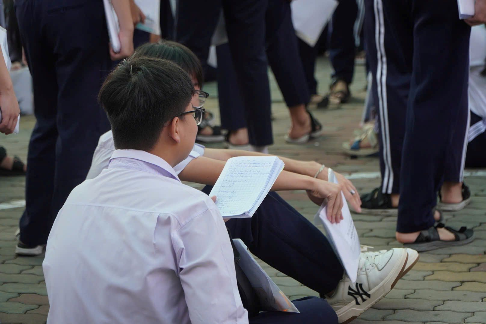 Một số thí sinh tranh thủ ôn lại bài trước lúc vào phòng thi. Ảnh: Chân Phúc