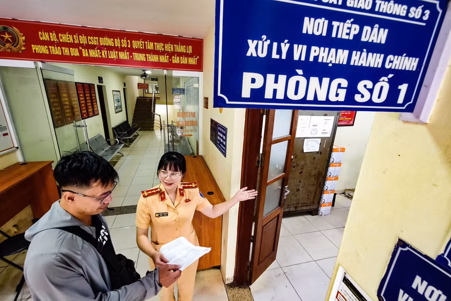 Cán bộ CSGT hướng dẫn người dân thực hiện xử lý vi phạm hành chính. csgt-2.jpg