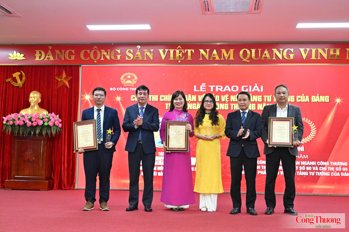 Đồng chí Nguyễn Đức Lợi, Phó Chủ tịch thường trực Hội Nhà báo Việt Nam và đồng chí Phan Văn Bản, Ủy viên Ban Thường vụ, Phó Bí thư Chuyên trách Đảng ủy Bộ Công Thương (thứ hai từ trái sang) trao giải Nhì cho các tác giả, nhóm tác giả đoạt giải.