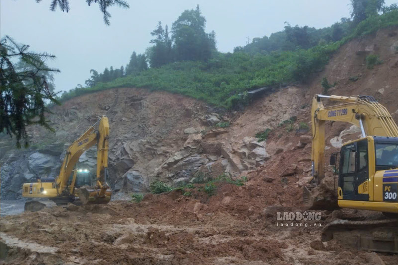 Máy móc được huy động khẩn trương hót dọn đất đá, thông đường do mưa lớn. Ảnh: Đinh Đại