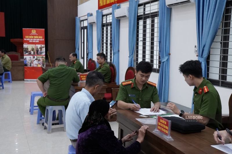 Cán bộ công an hướng dẫn người dân hoàn thiện thông tin trước khi lấy mẫu ADN. Ảnh: Đinh Đại